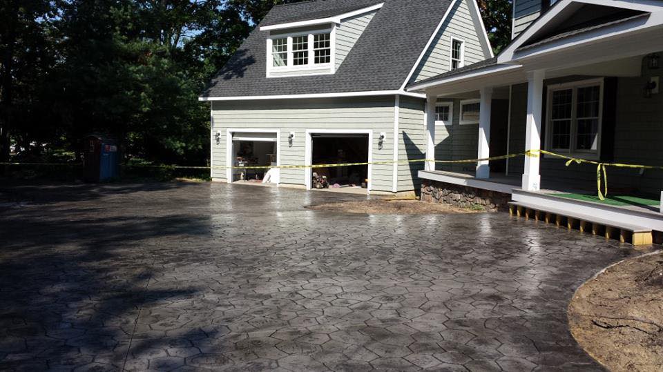 A house with a garage and a driveway in front of it.