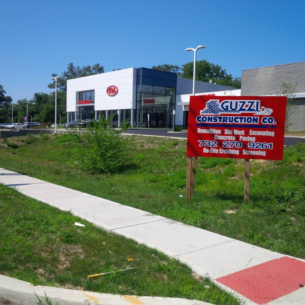A red sign that says guzzi construction co. in front of a building