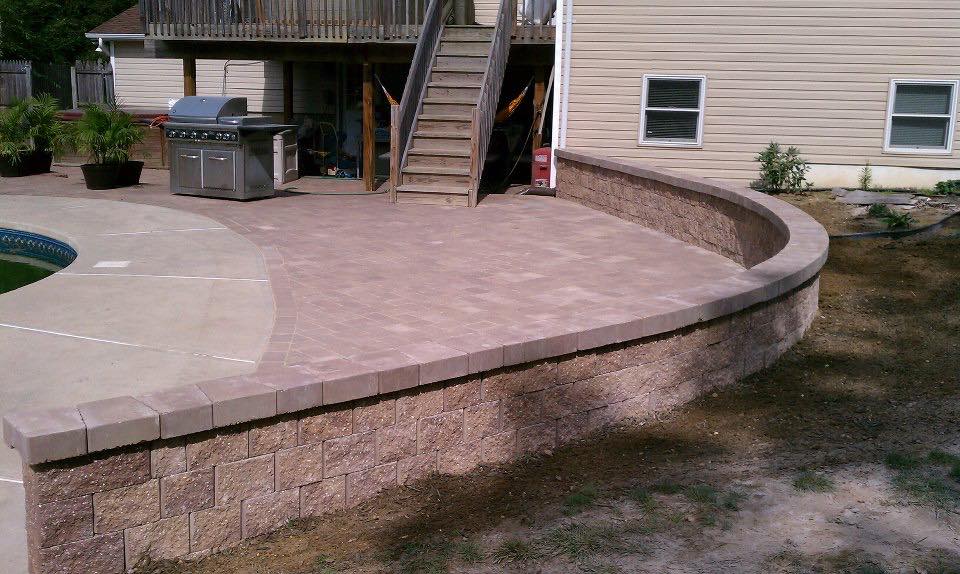 A patio with a grill and stairs leading to a house