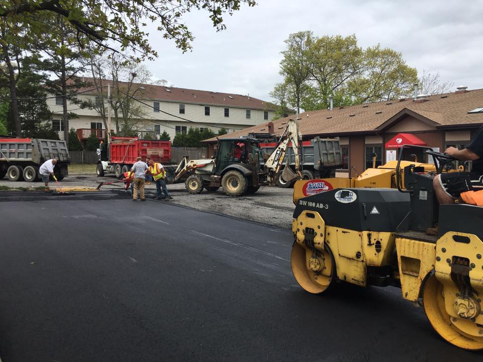 A group of construction workers are working on a road.