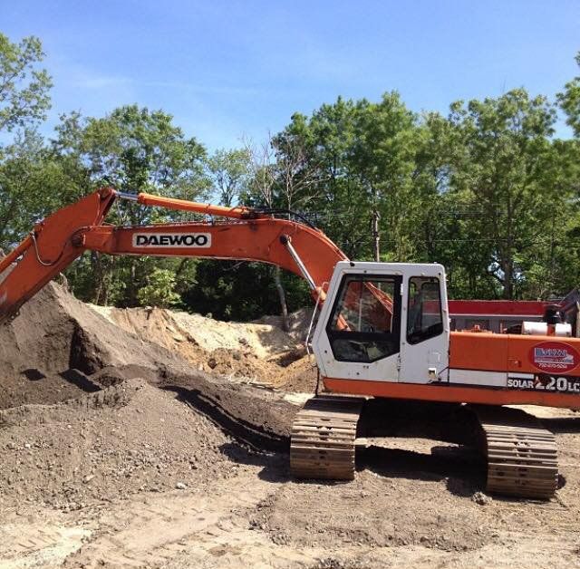 A daewoo excavator is sitting in a pile of dirt