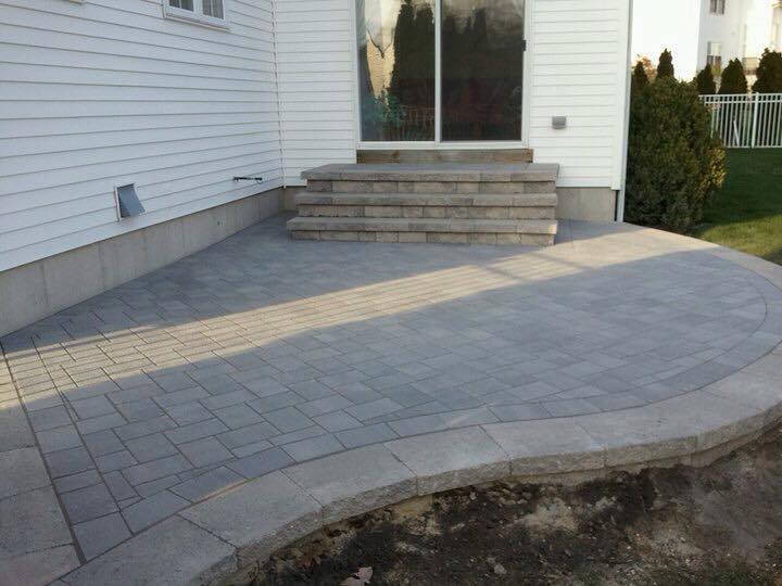 A white house with a patio and stairs in front of it