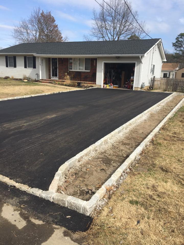 A house with a garage and a driveway in front of it.