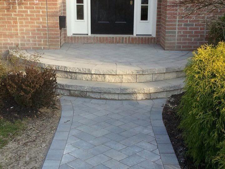 A walkway leading to the front door of a brick house