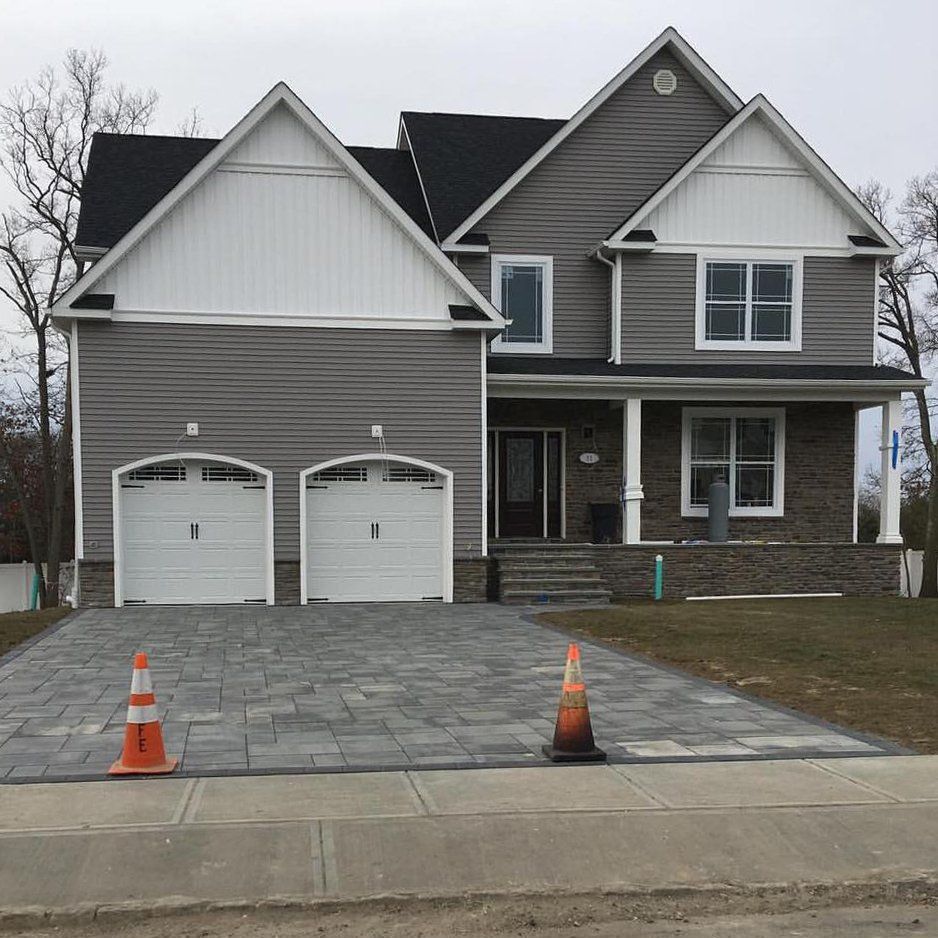 A large house with two garage doors and a driveway
