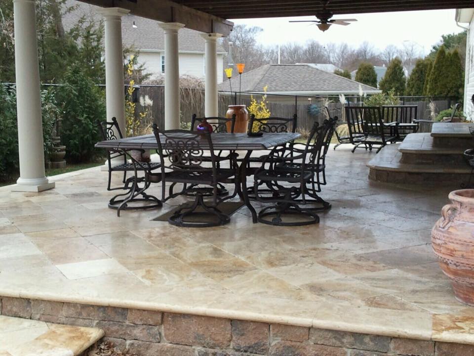 A patio with a table and chairs under a ceiling fan