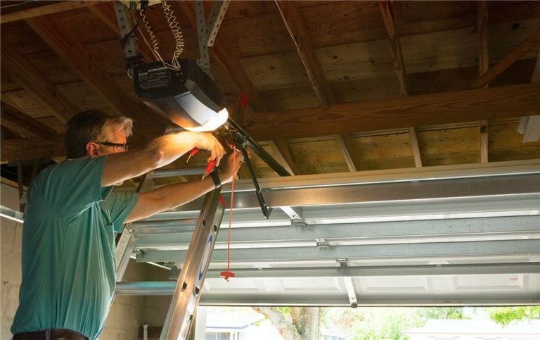 a man is working on a garage door opener in a garage