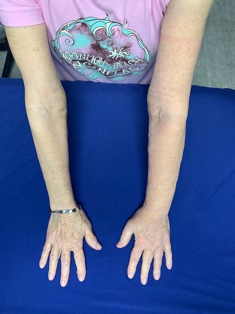 A woman in a pink shirt has her hands on a blue cloth