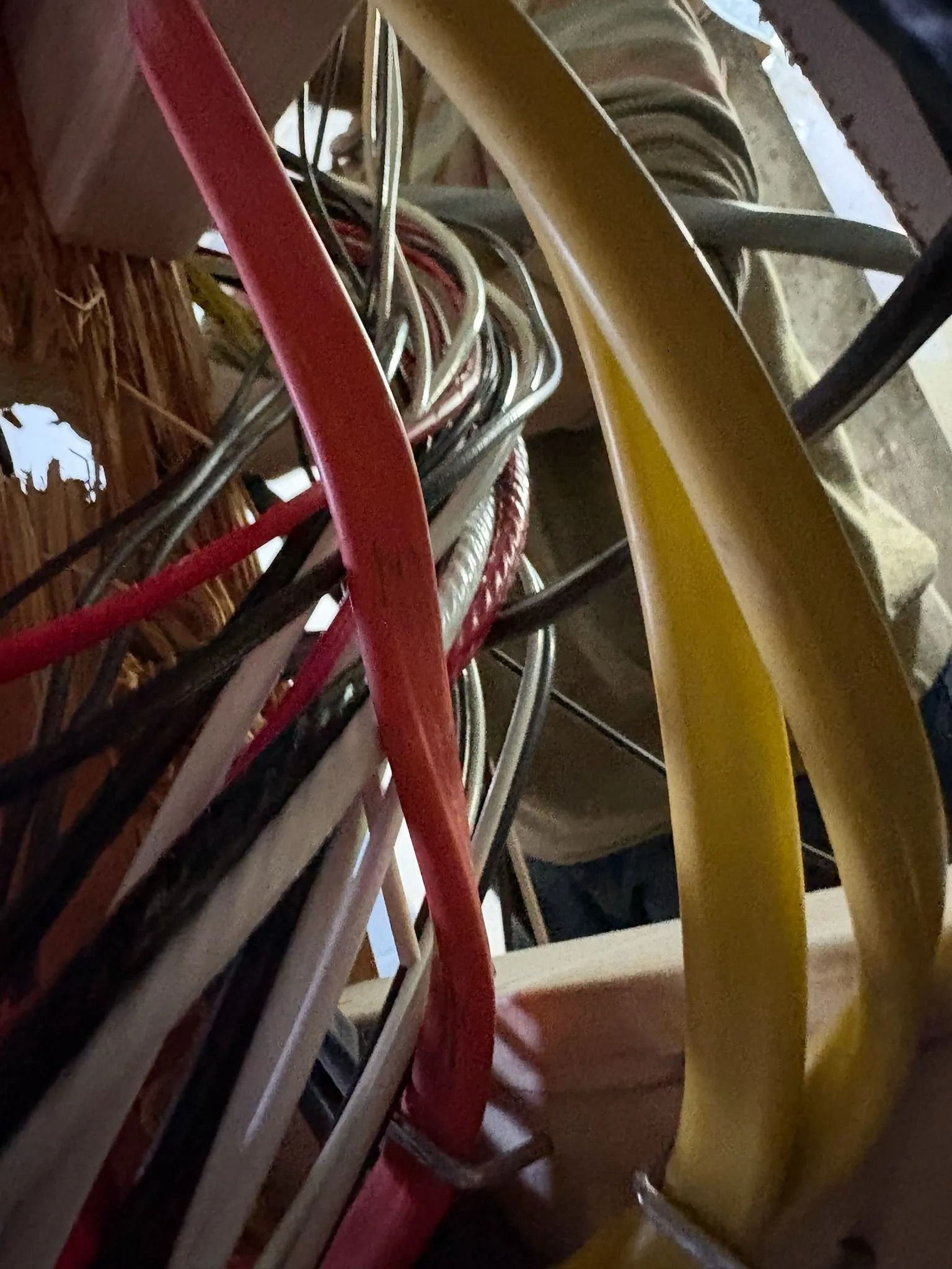 Close-up of electrical wires in an enclosure. Red, yellow, black, and white cables are visible.