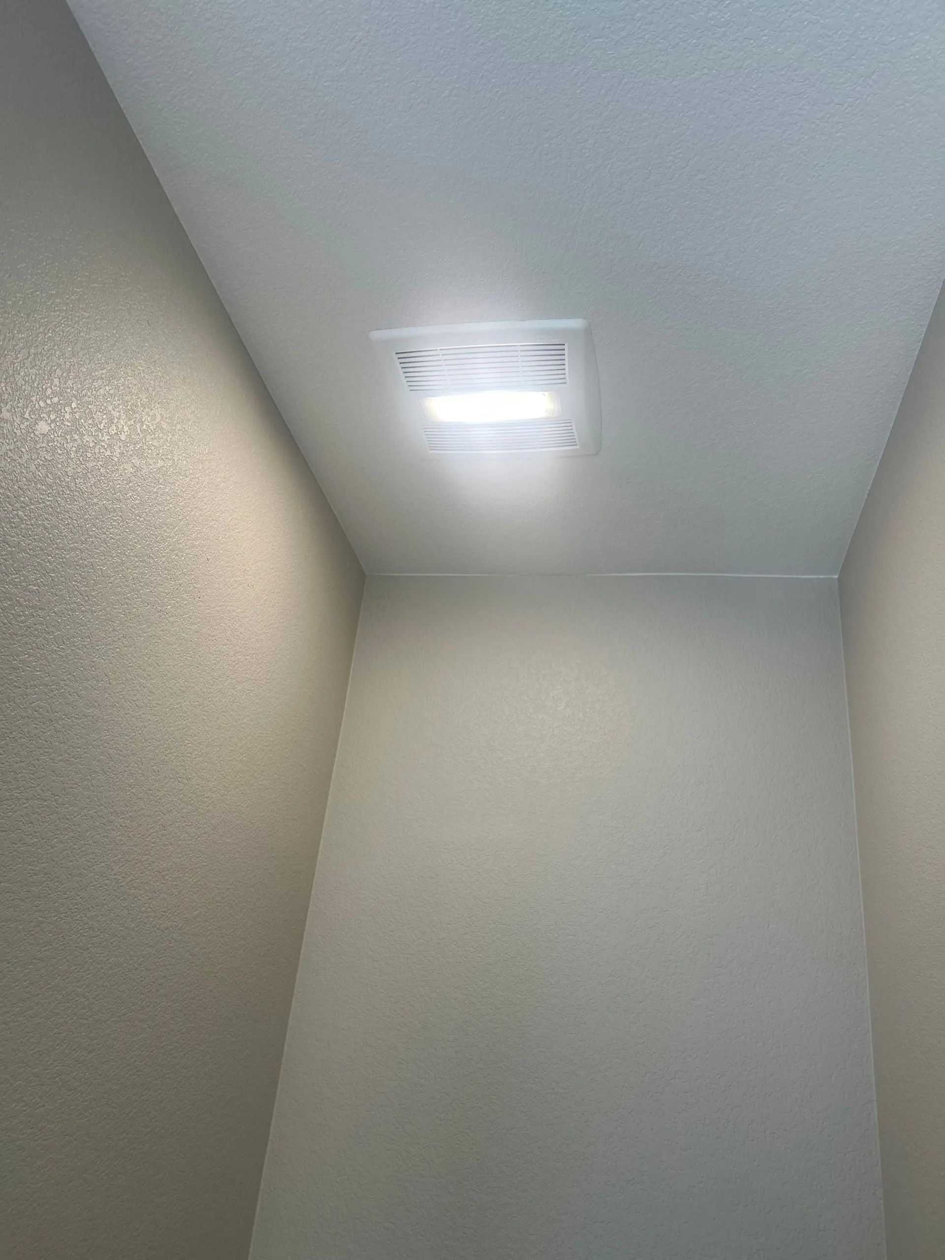 A rectangular ceiling light in a small room with light-colored walls and ceiling.