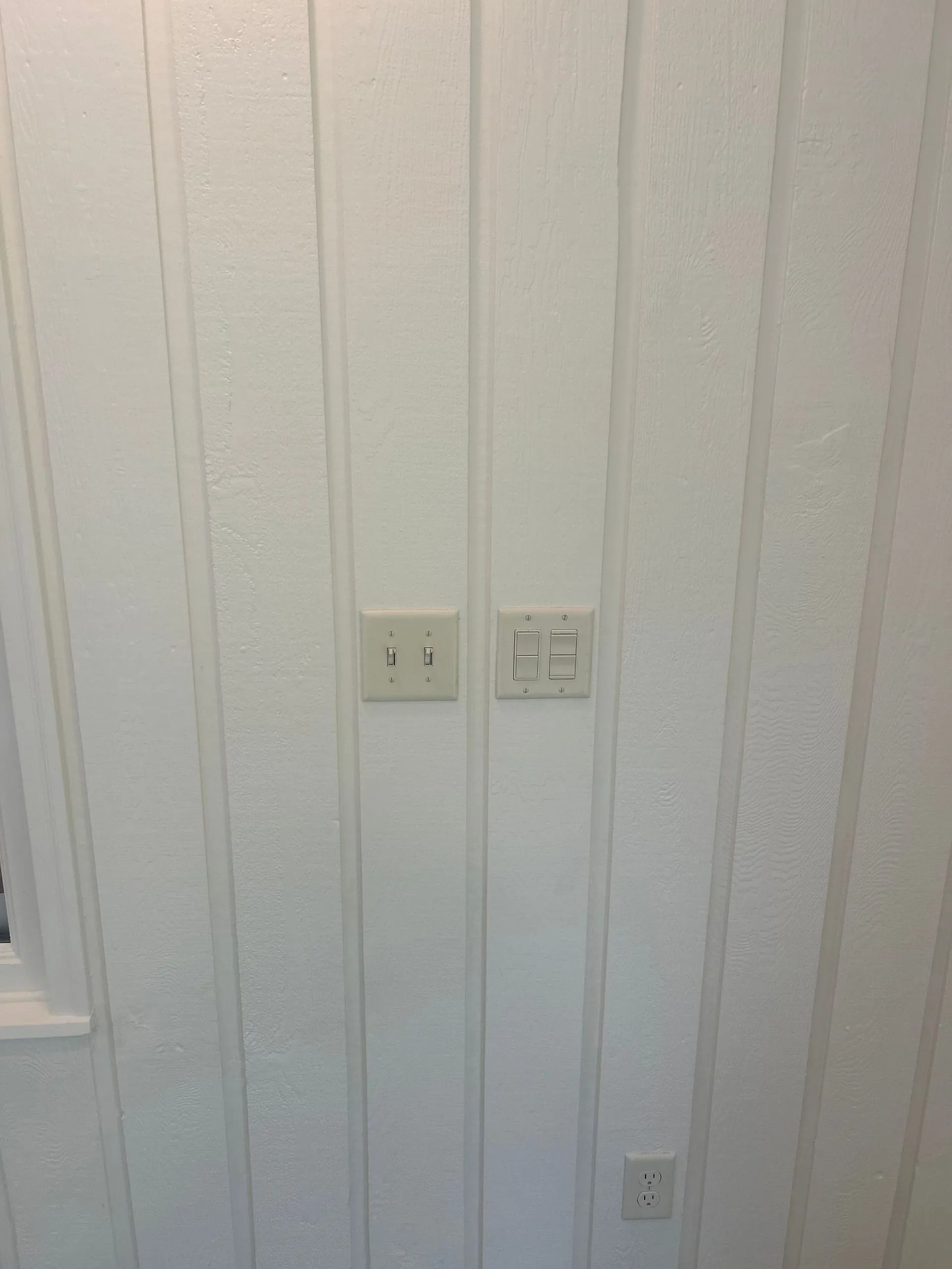 White wall with three electrical outlets and a switch.