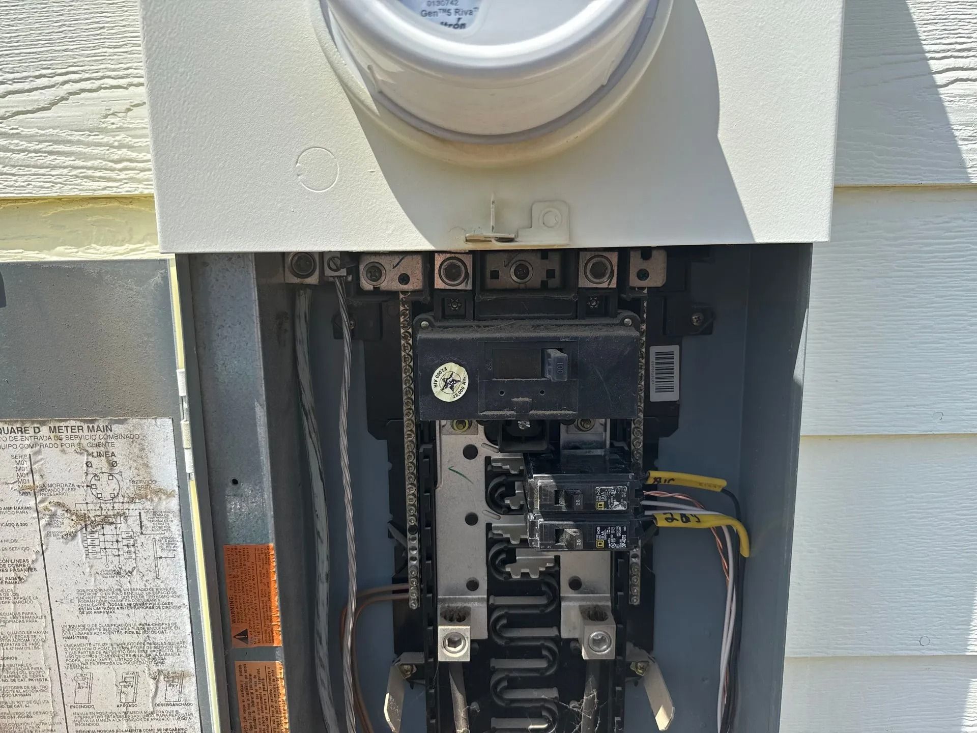 Open electrical box with a meter at the top and wiring.