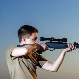 Man looking over gun scope