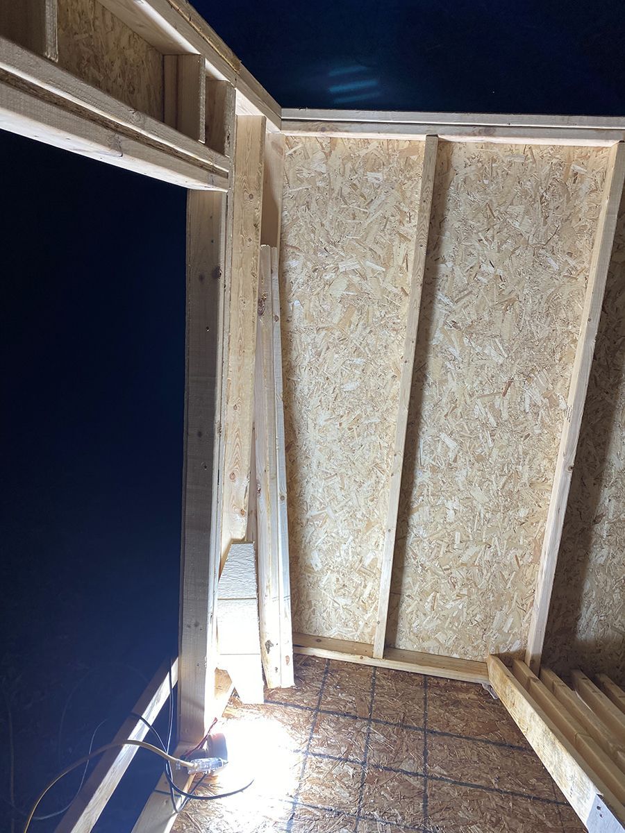 A room with a wooden wall and a light on the floor.