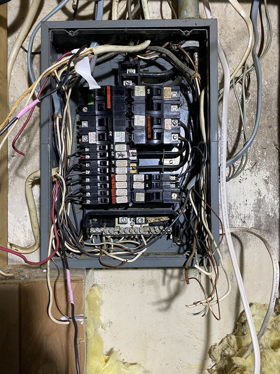 A very messy electrical box with a lot of wires coming out of it.