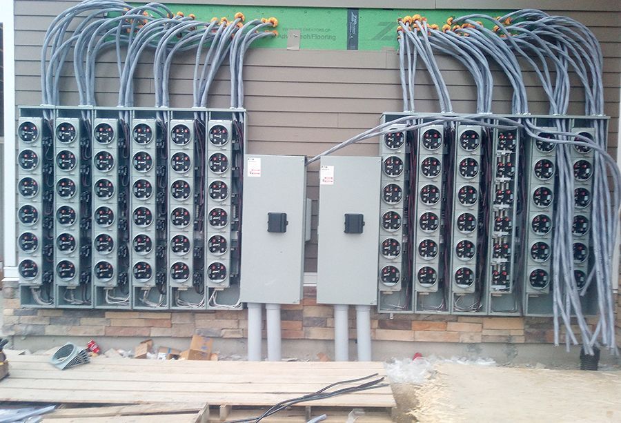 A row of electrical boxes on the side of a building.