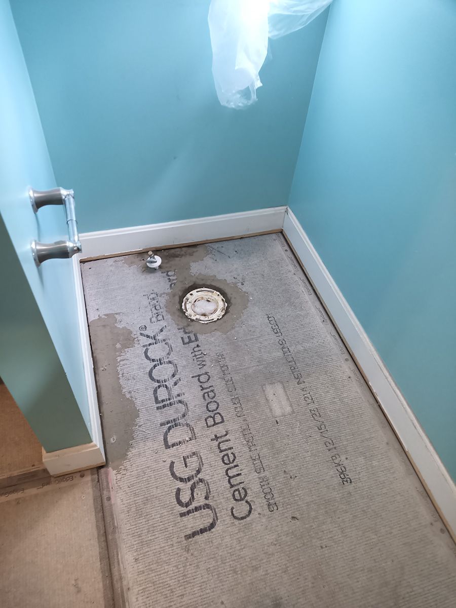 A bathroom with a cement board on the floor.