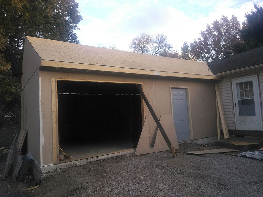 A garage under construction with the door open.