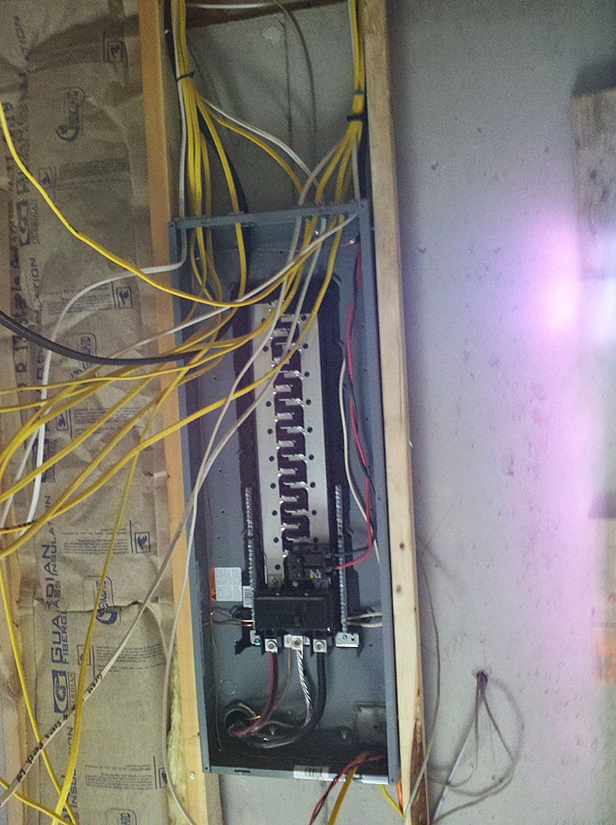 A bunch of wires are hanging from a wall.