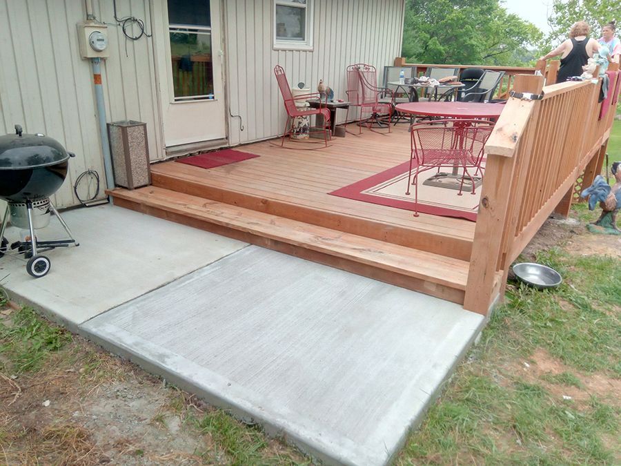 A wooden deck with a table and chairs and a barbecue grill.
