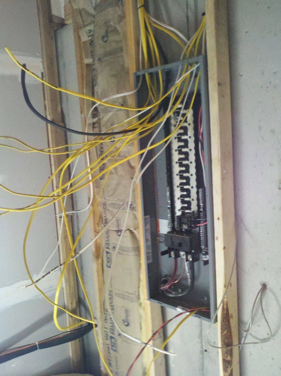 A bunch of wires are hanging from a wall.