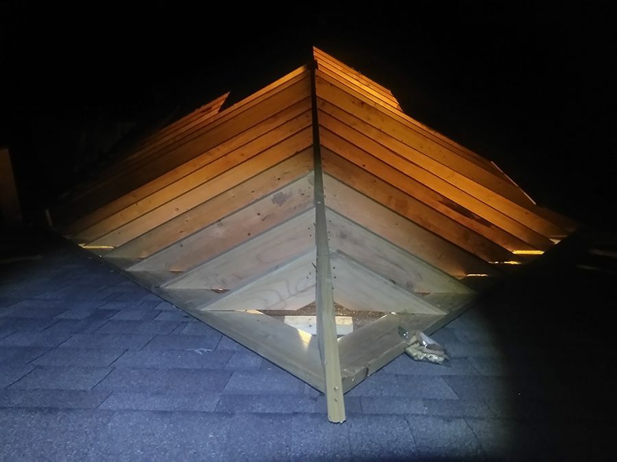 A wooden structure is being built in the dark.