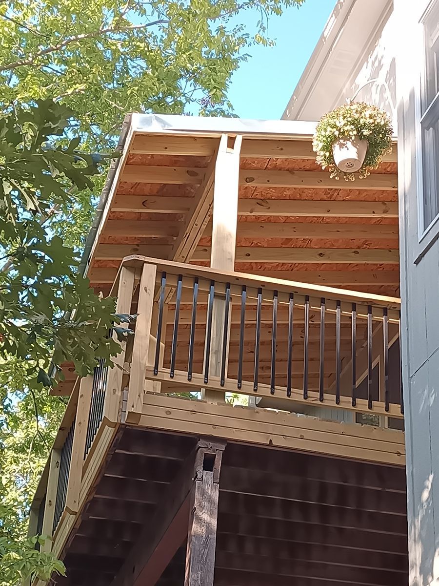 A wooden deck with a planter on top of it.