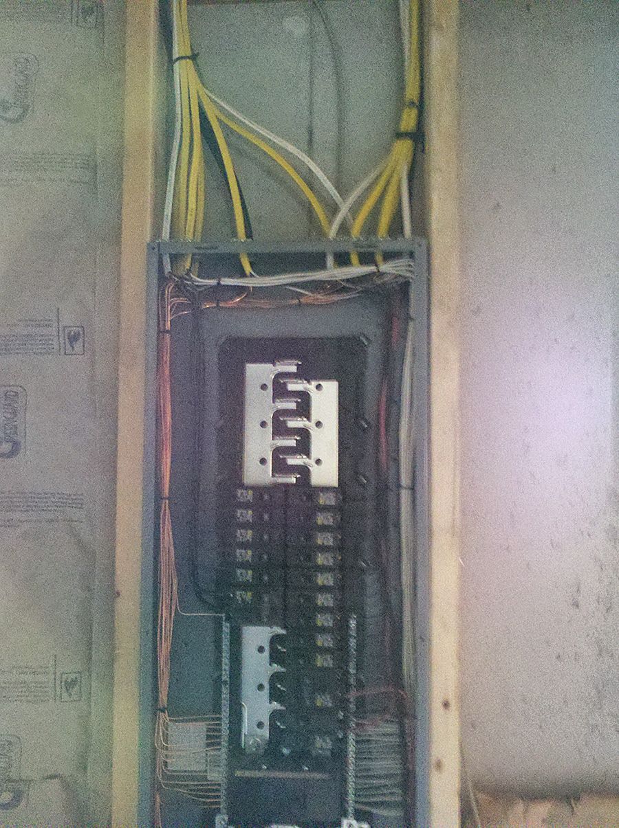 A black and white electrical box with yellow wires coming out of it.