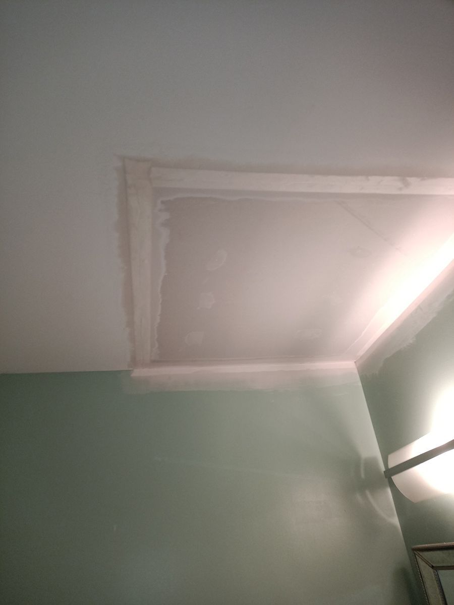 A room with a white ceiling and a light on the wall.