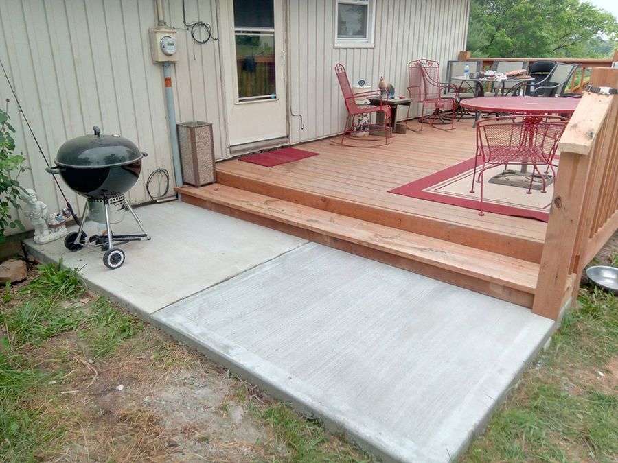 A wooden deck with a table and chairs and a grill.