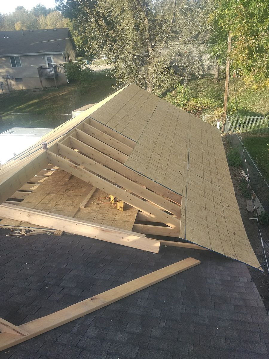 A roof is being built with wooden beams and shingles.