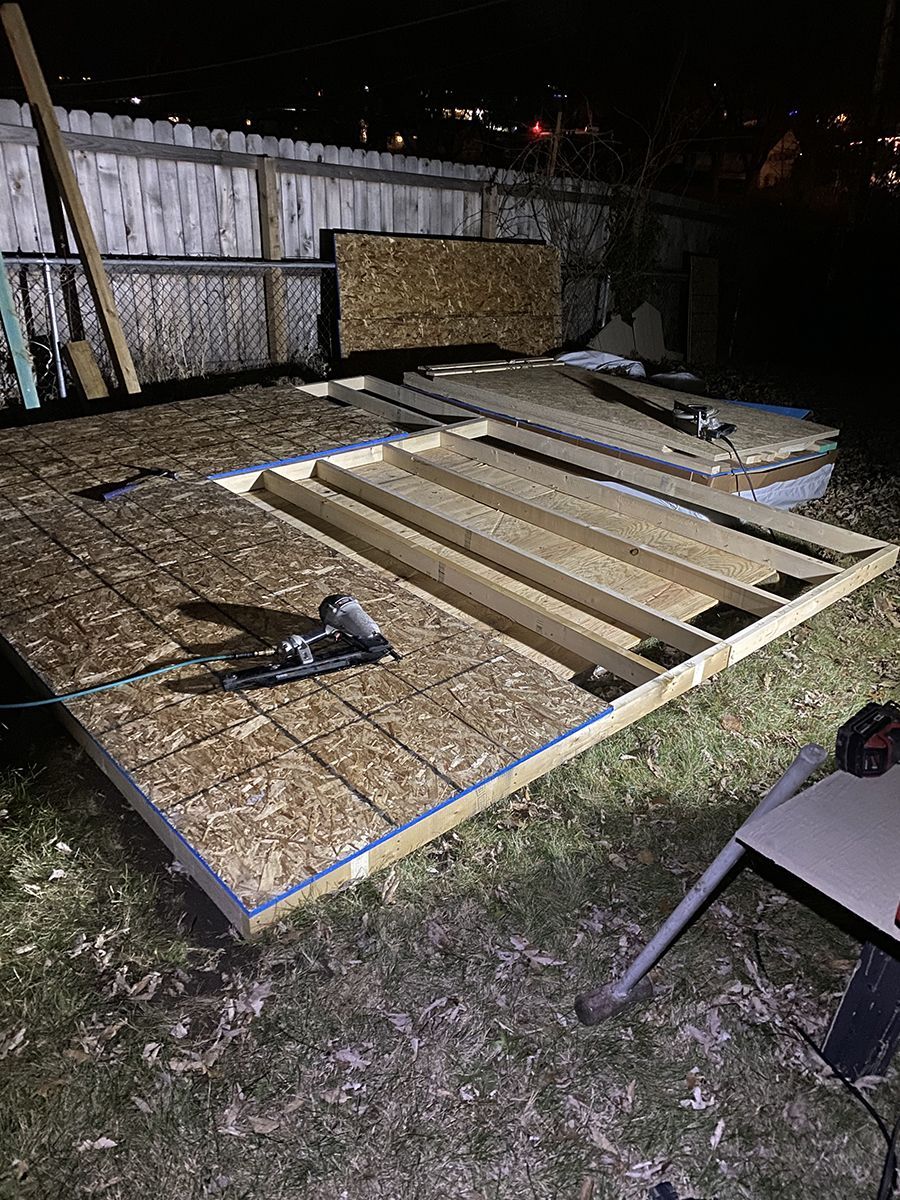 A shed is being built in the backyard at night.
