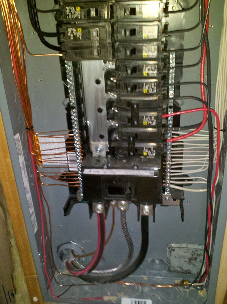 A close up of a electrical panel with red wires coming out of it.