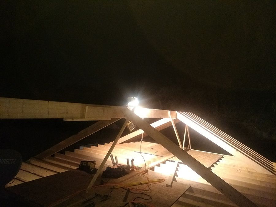 A light is shining on a wooden structure at night.