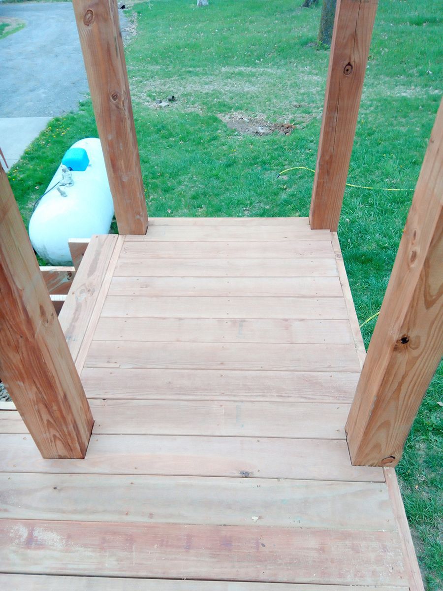 A wooden deck with a propane tank in the background.