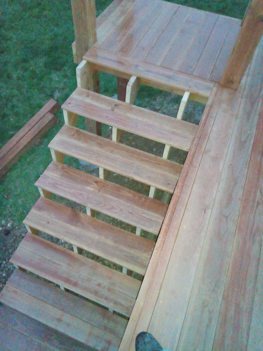 The stairs are made of wood and are being built on a deck.