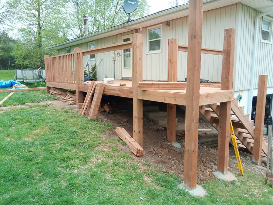 A wooden deck is being built in front of a mobile home.