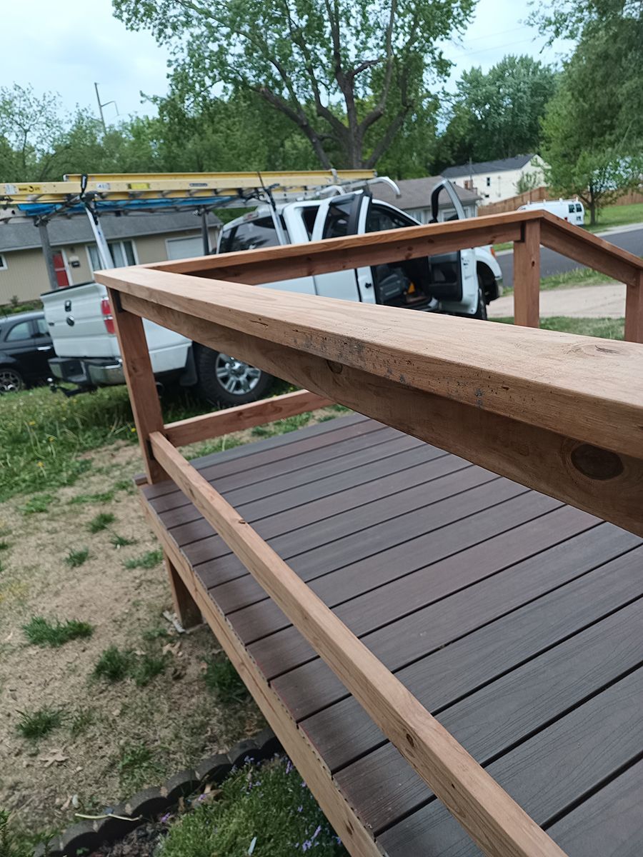 A wooden deck with a truck parked in the background.