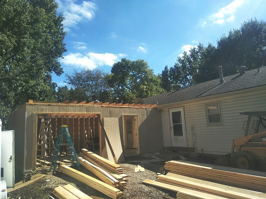 A house that is being remodeled with a lot of wood in front of it.