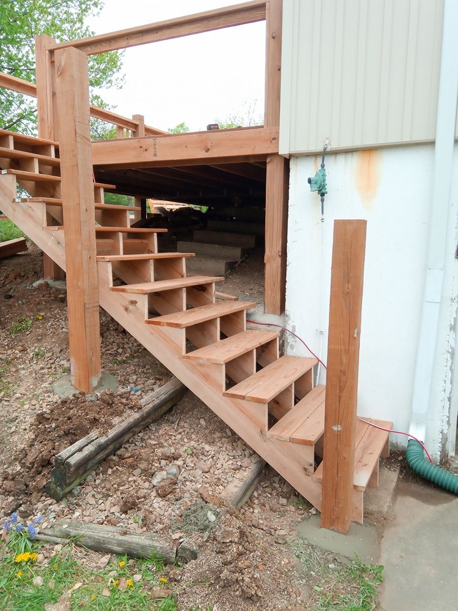 A set of wooden stairs leading up to a house.
