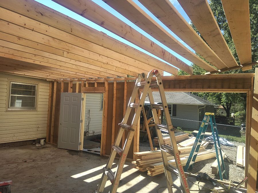 A ladder is sitting in front of a house under construction.