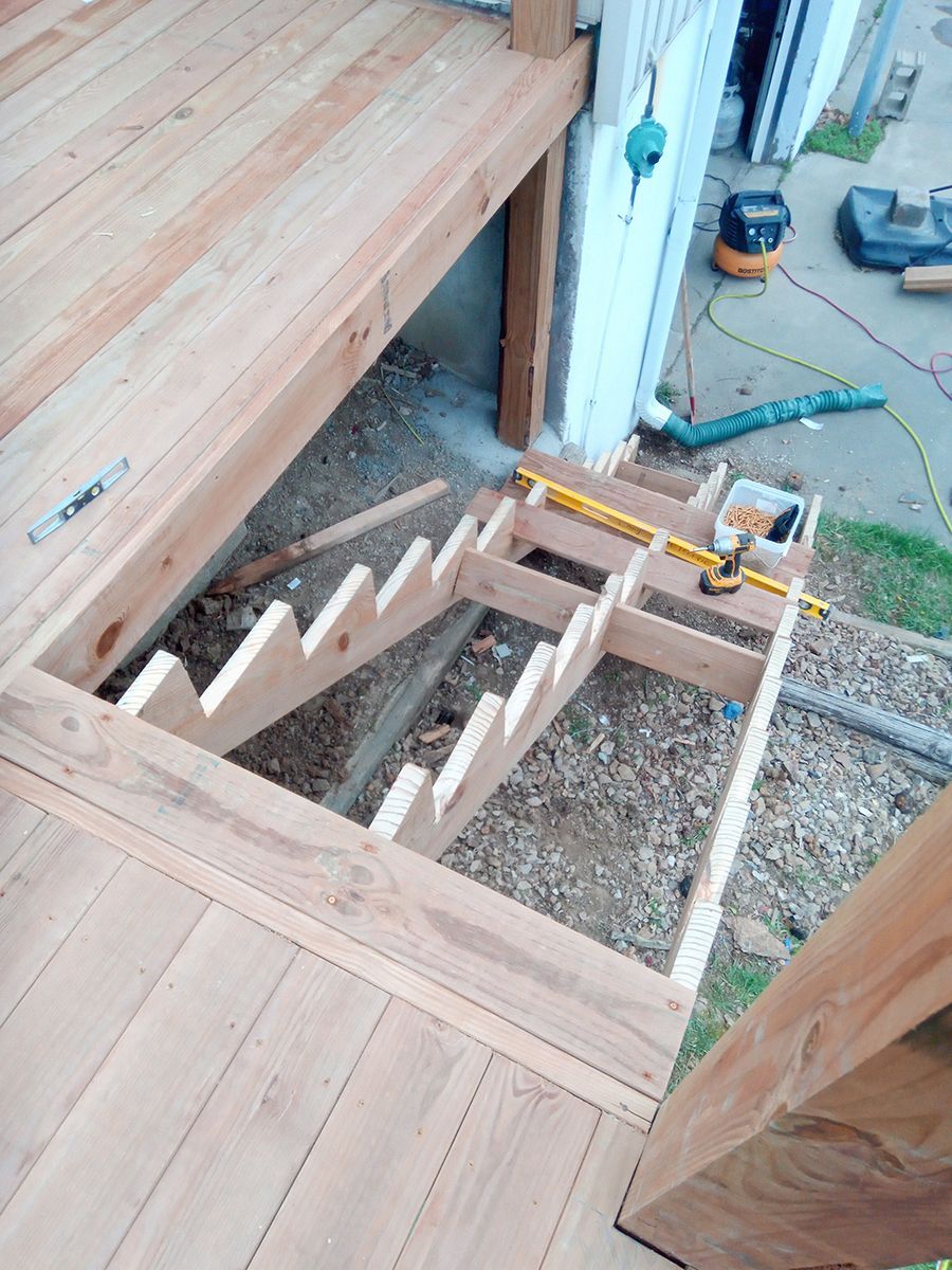 A wooden staircase is being built on top of a wooden deck.
