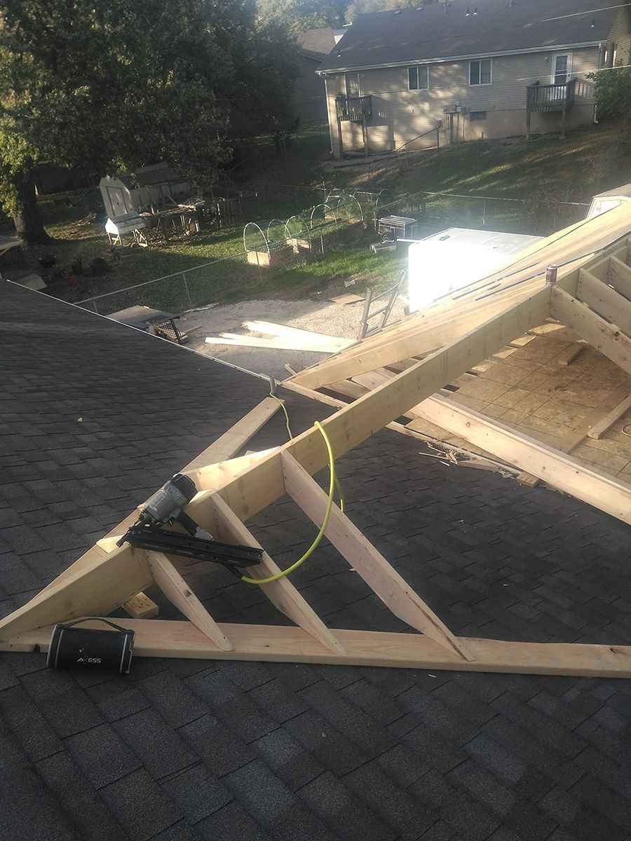 A wooden structure is being built on top of a roof.