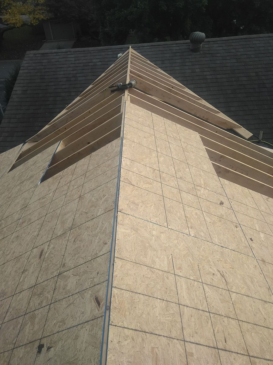 A roof with a triangle shaped roof being built.