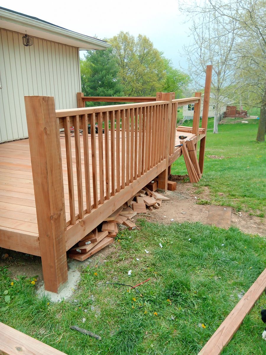 A wooden deck is being built in the backyard of a house.