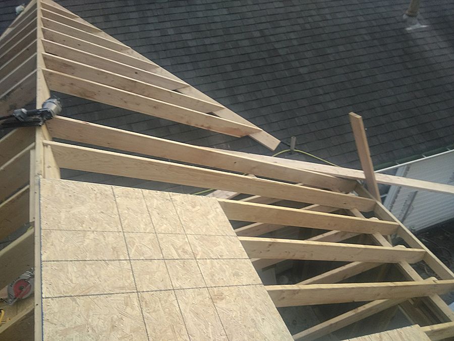 A wooden structure is being built on top of a roof.