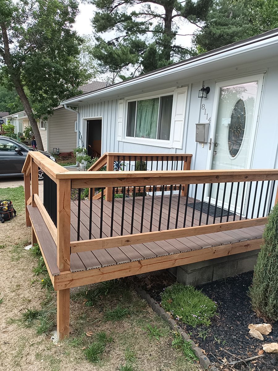 A wooden deck is sitting in front of a white house.