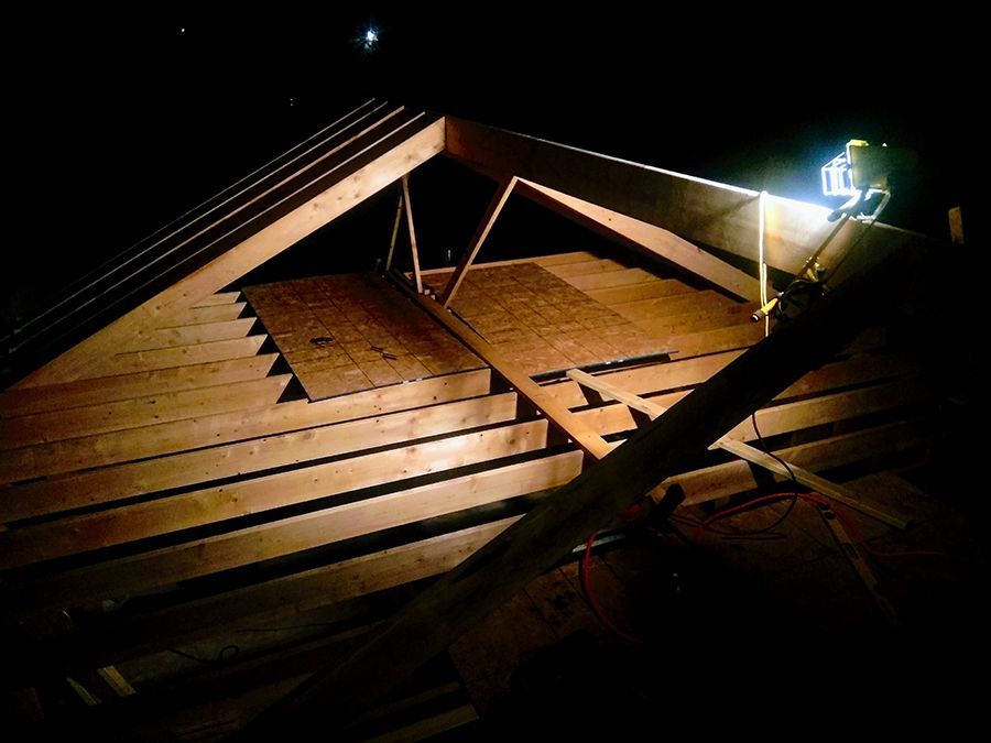 A light is shining on a wooden structure at night.