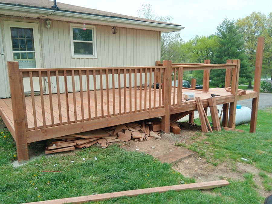 A wooden deck is being built in front of a house.