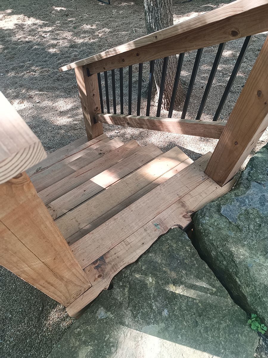 A wooden chair is sitting on top of a rock.
